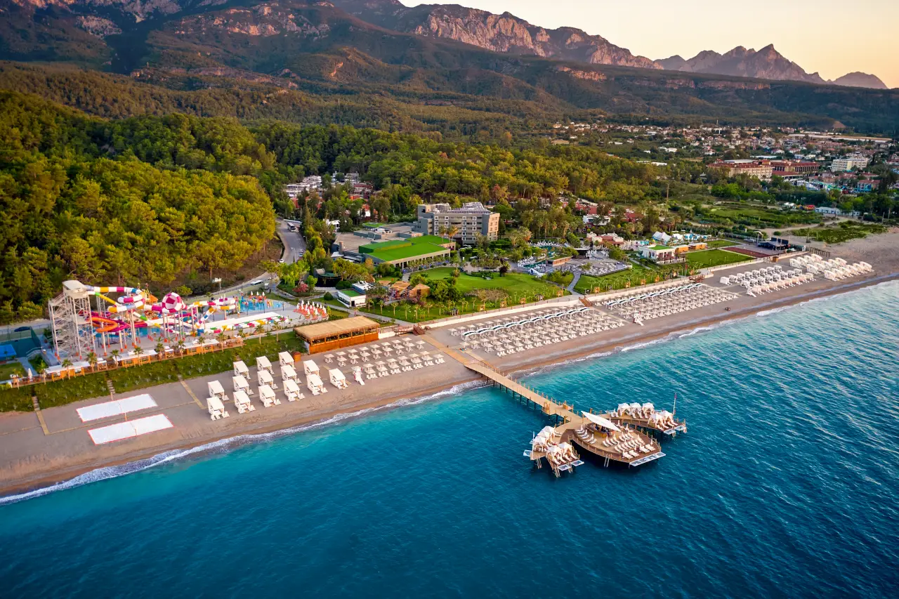 Mövenpick Resort Antalya Tekirova'nın havadan çekilmiş görüntüsü, yeşilin ve mavinin muhteşem uyumuyla çevrili lüks tatil köyü