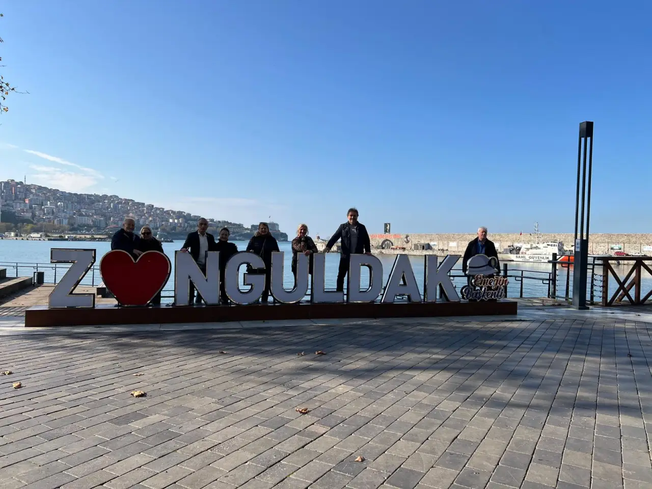 Zonguldak sahilinde ‘Z ♥ NGULDAK’ yazısının önünde poz veren bir grup insan.