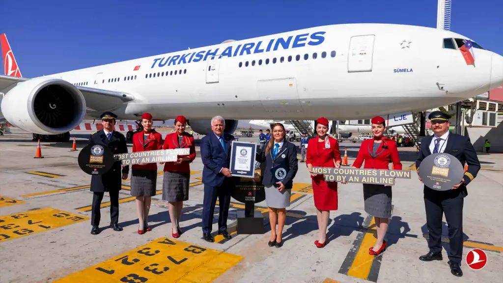 Türk Hava Yolları ekibi, Guinness Dünya Rekoru sertifikasıyla uçağın önünde poz veriyor.
