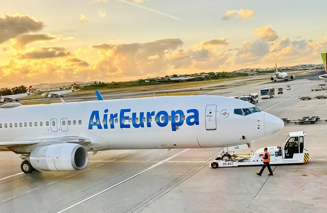 Air Europa uçağı, gün batımında havalimanında yer hizmetleri tarafından çekilirken.