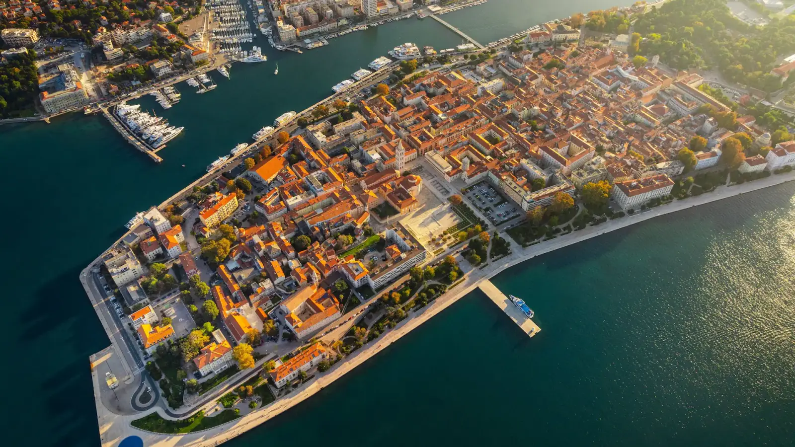 Zadar’ın tarihi merkezi, Adriyatik Denizi kıyısında, havadan görüntülenmiş kırmızı çatılı binaları ve tarihi dokusuyla parlıyor.