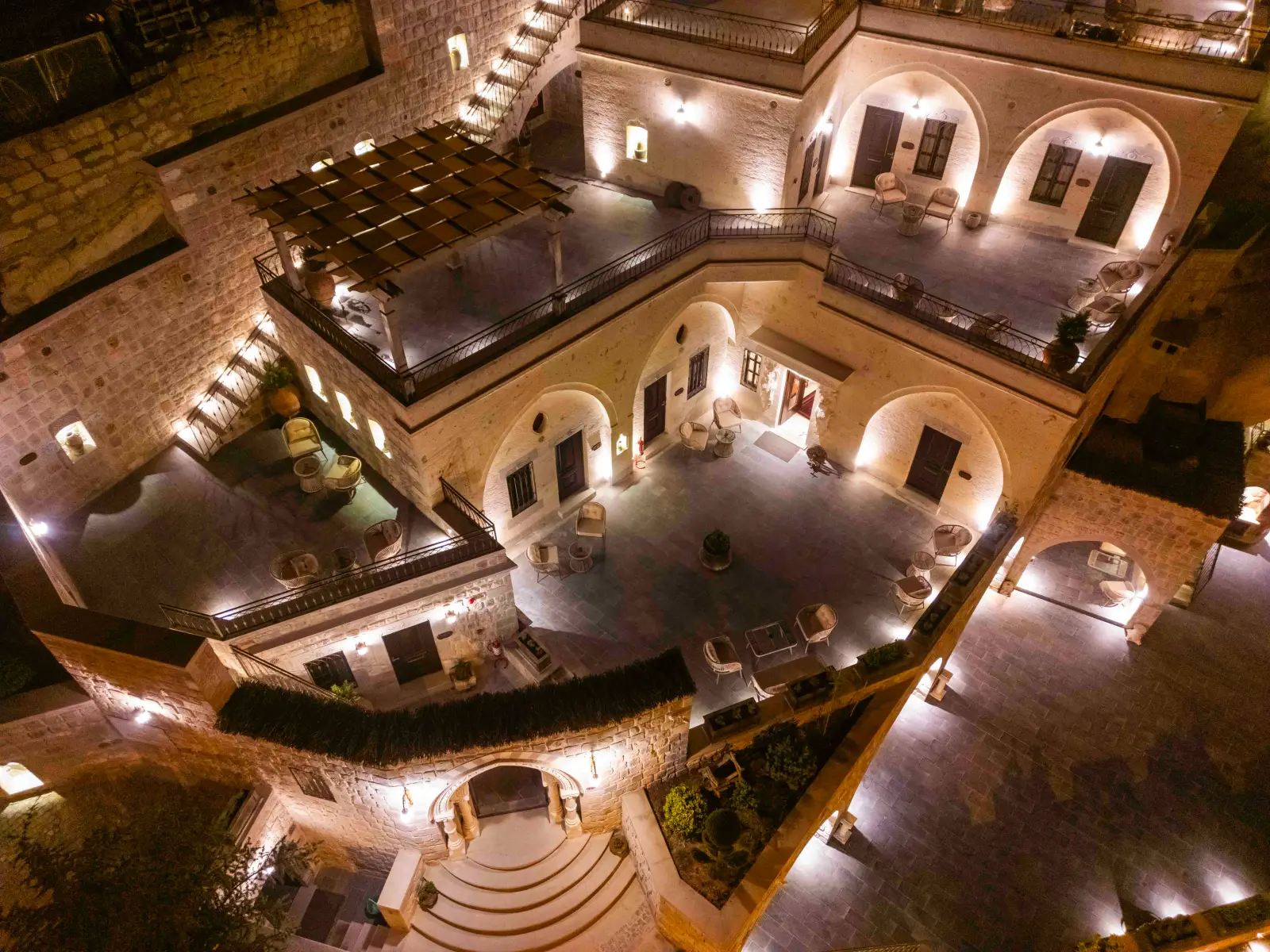 Kapadokya’da gece ışıklarıyla aydınlatılmış Signature Cave Cappadocia oteli avlusu