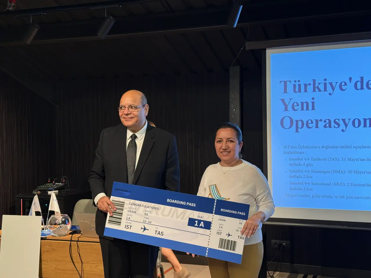 Centrum Air etkinliğinde ücretsiz bilet kazanan konuklar sembolik biniş kartıyla poz veriyor