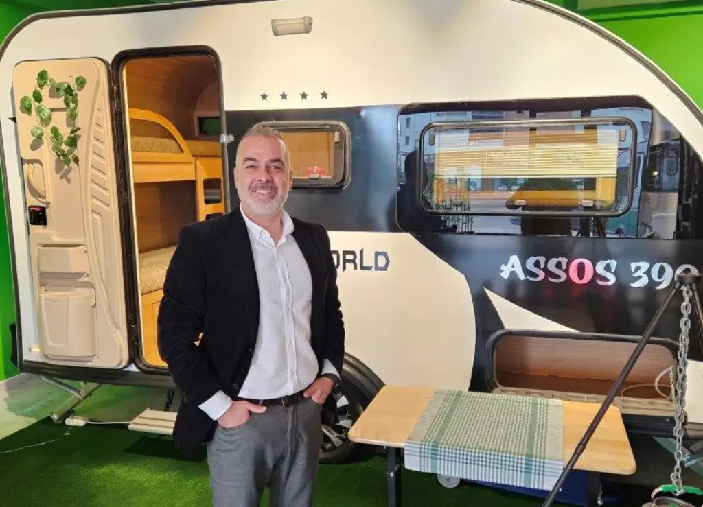 Tamer Karaoğlu, Hobbyfest Türkiye Direktörü, Assos 390 karavan modelinin önünde gülümseyerek poz veriyor