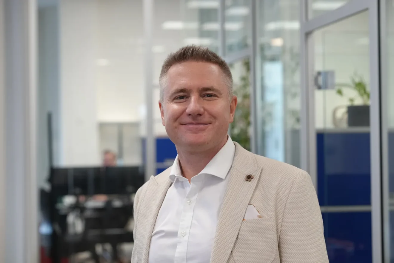 Açık renk ceket ve beyaz gömlek giymiş Bentour Reisen CEO’su Deniz Uğur’un modern bir ofis ortamında çekilmiş profesyonel portresi.