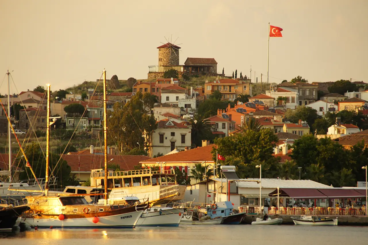Ayvalık’ta gün batımı manzarasında yel değirmeni ve Türk bayrağı