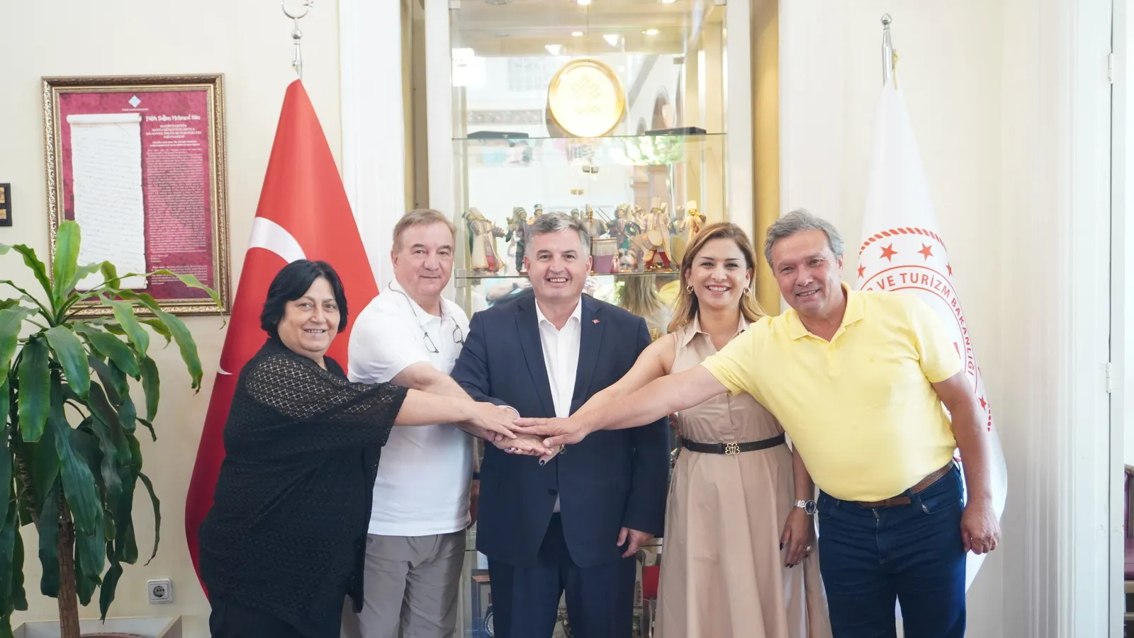 ETİK heyeti ve İzmir İl Kültür ve Turizm Müdürü Sadık Doğruer, turizm iş birliği toplantısı sonrası el ele poz veriyor.