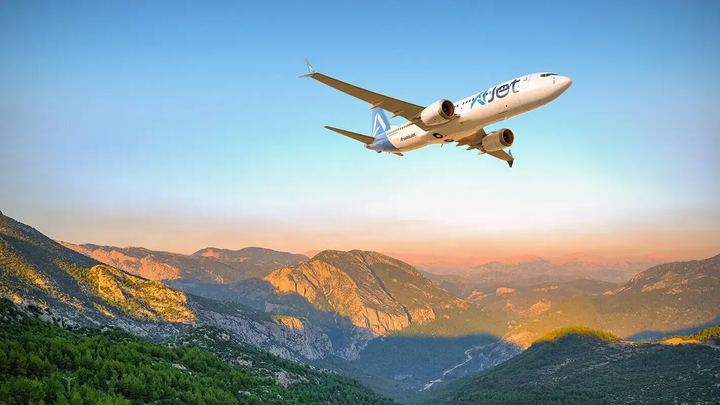 AJet Boeing 737 yolcu uçağı dağlar üzerinde gökyüzünde süzülüyor.