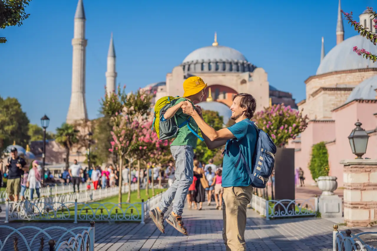 İstanbul’da Ayasofya önünde bir baba ve oğlu keyifli anlar yaşarken turistler çevrede geziyor.