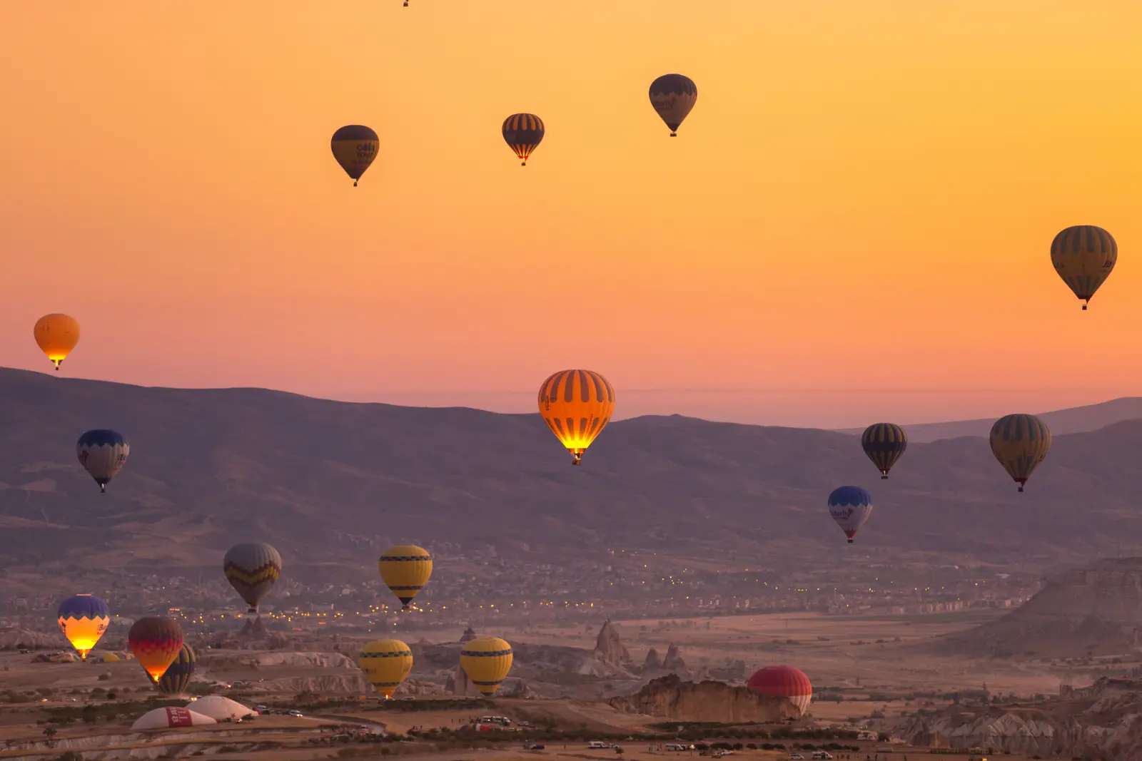 Kapadokya’da gün doğumunda gökyüzünde süzülen sıcak hava balonları.