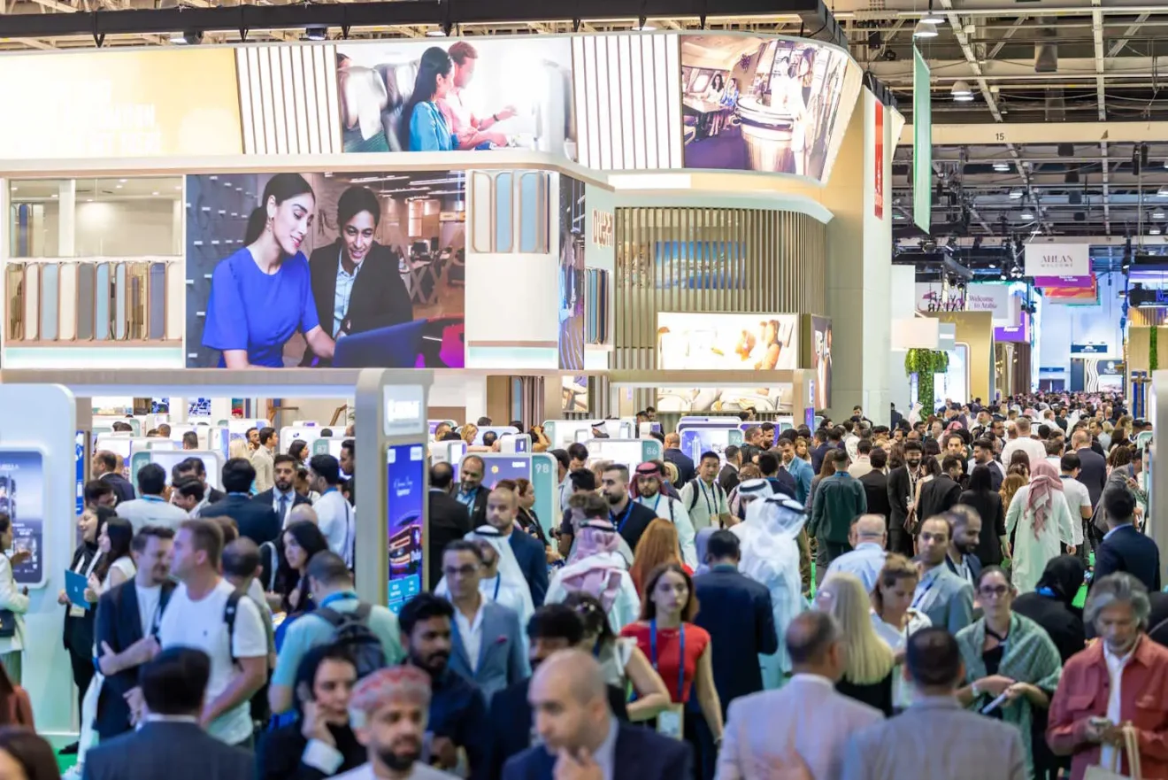 Visitors explore crowded exhibition halls at Arabian Travel Market in Dubai, showcasing global tourism brands.