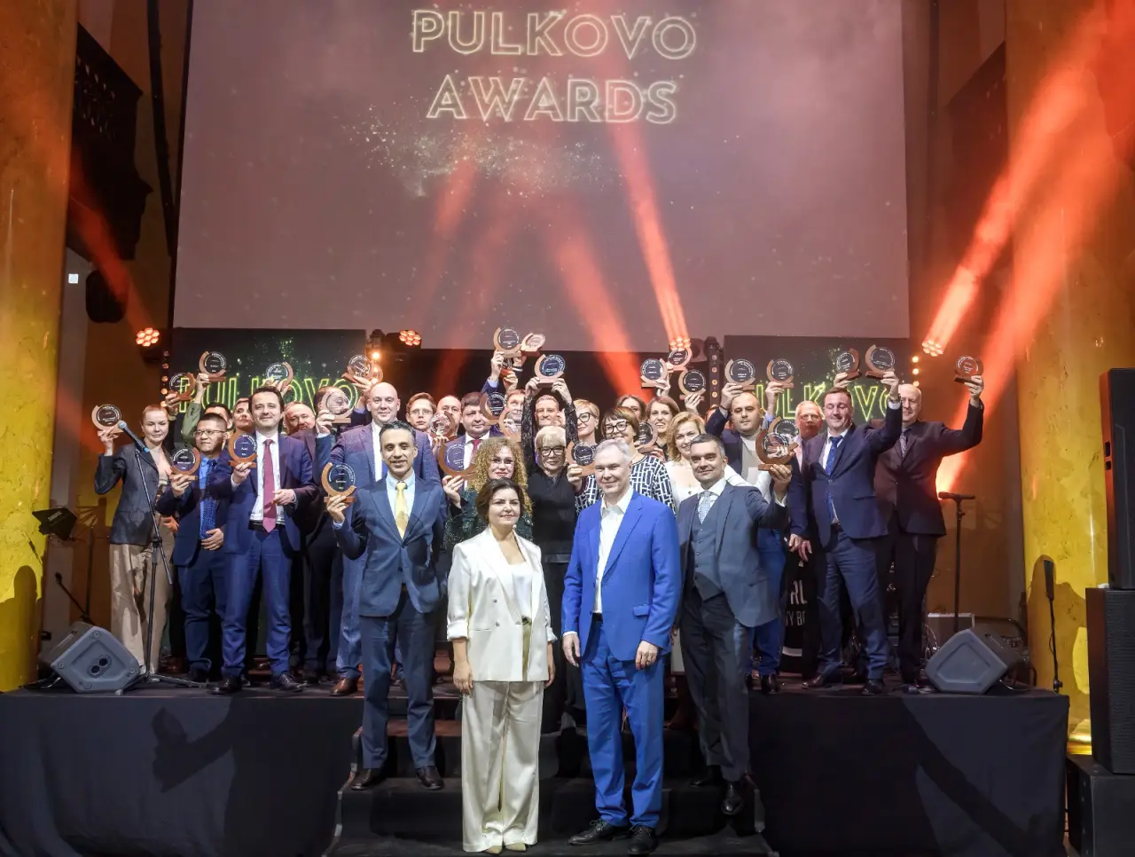 St Petersburg Pulkovo Awards töreninde sahnede ödüllerini kaldıran havayolu ve turizm sektörü temsilcileri toplu halde poz veriyor.