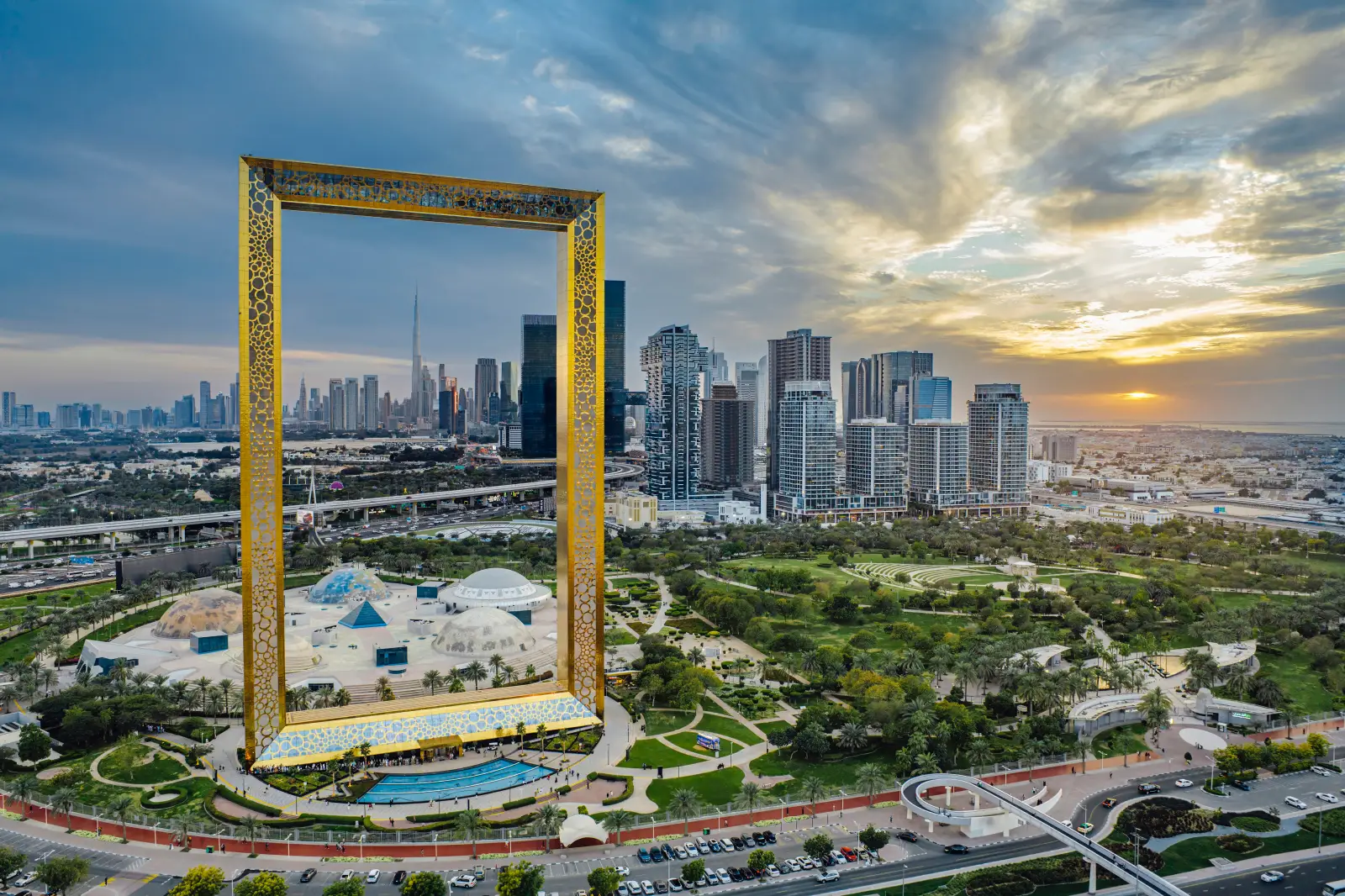 Dubai Frame ve şehir silüetini gün batımı manzarasıyla gösteren hava çekimi.