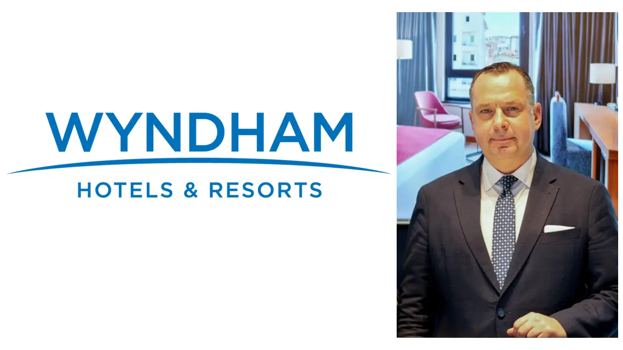 Wyndham Hotels & Resorts logosu yanında, otel odası arka planında takım elbiseli Arcan Bayraktaroğlu