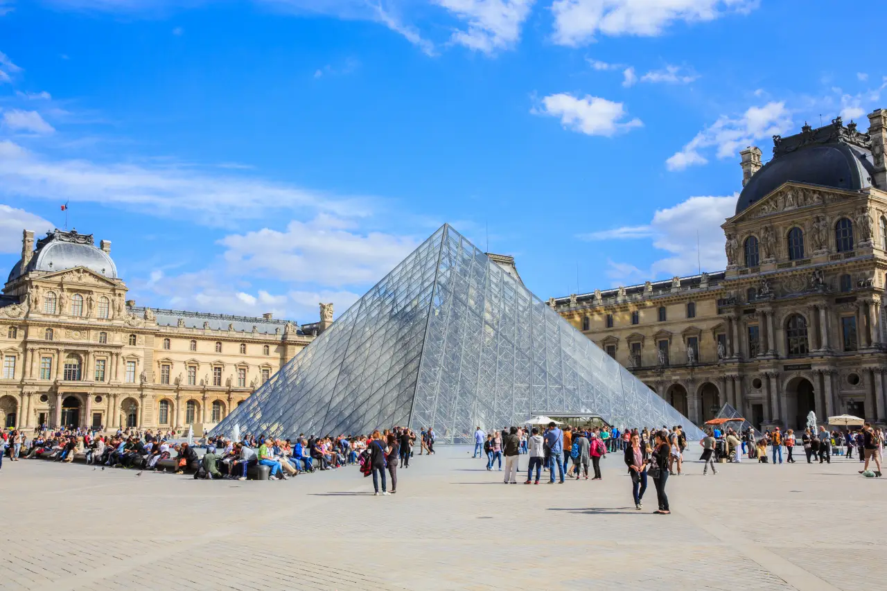 Louvre Müzesi önündeki cam piramit etrafında toplanan kalabalık turistler
