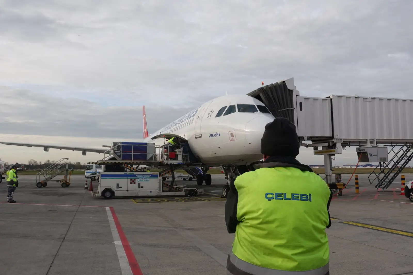 Çelebi Havacılık personeli, havalimanında Türk Hava Yolları uçağına yer hizmetleri verirken apron üzerinde çalışıyor