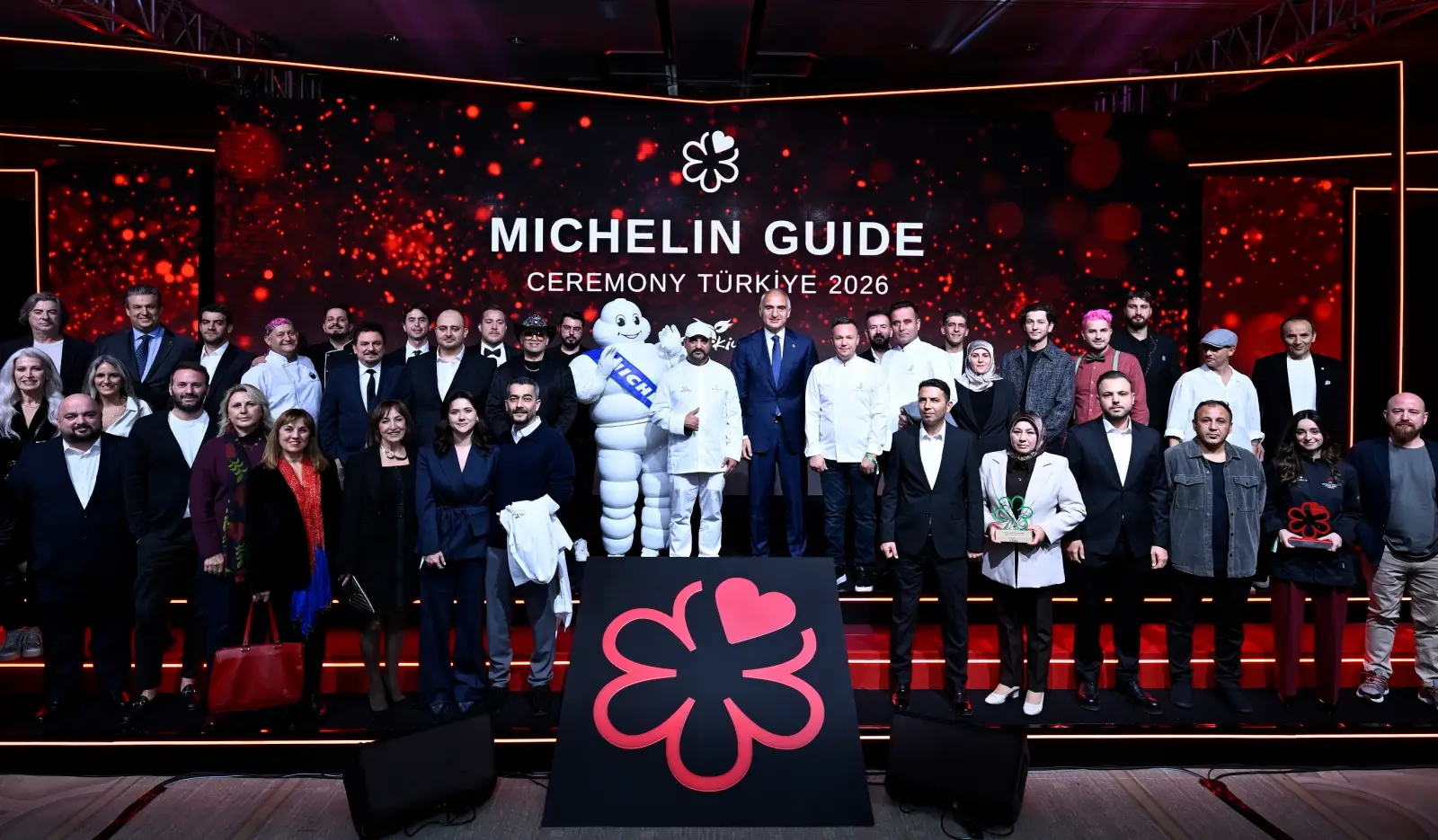 Michelin Rehberi Türkiye 2026 töreninde sahnede şefler, sektör temsilcileri ve Michelin maskotu birlikte poz veriyor