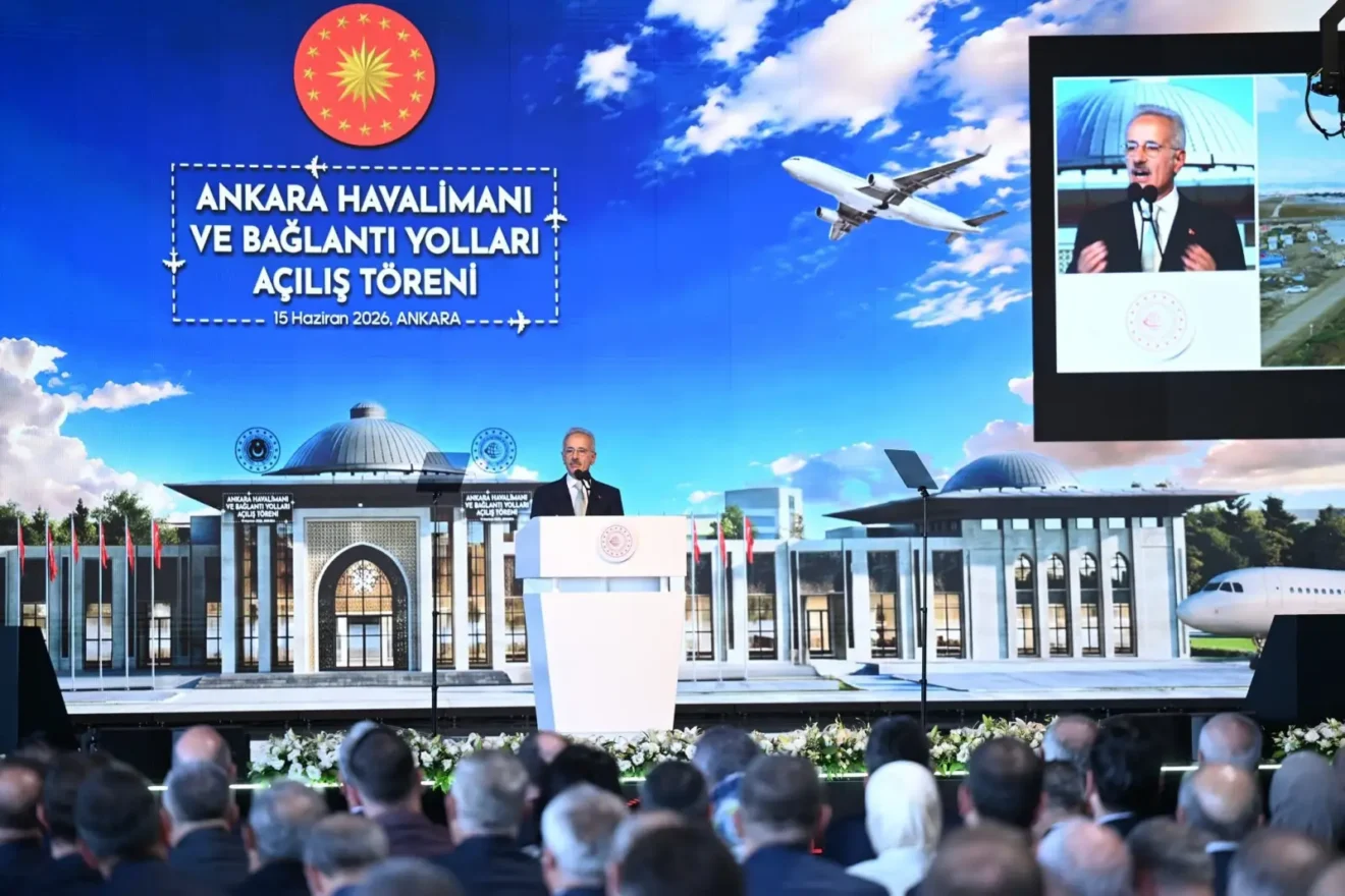 Ulaştırma ve Altyapı Bakanı Abdulkadir Uraloğlu, 15 Haziran 2026'da Ankara'da düzenlenen Ankara Havalimanı ve Bağlantı Yolları Açılış Töreni'nde kürsüden konuşuyor. Arka planda havalimanı terminal binasının görselini ve uçakları içeren büyük ekran ile Cumhurbaşkanlığı arması yer alıyor.