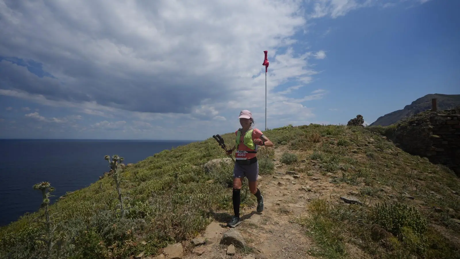Gökçeada Ultra Trail'de deniz manzaralı patikada koşan bir sporcu